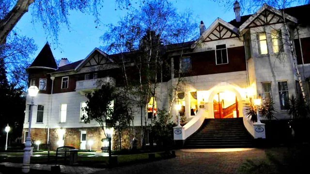 Wide view of an illuminated historic building and entrance at dusk