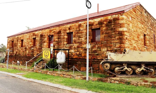 Sandstone exterior of Heidelberg Old Jail with barred windows and a military display