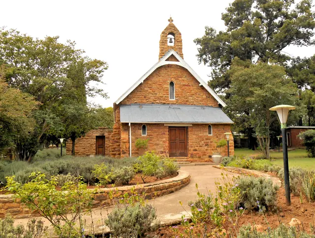 Stone church with a small bell tower and garden