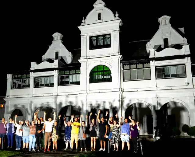 Guests in front of a white historic building illuminated at night