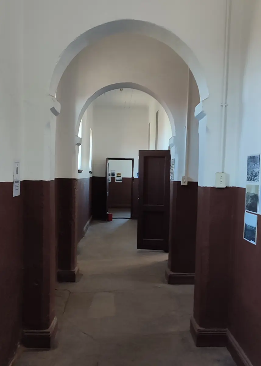 Long corridor with repeated arches and cell doors