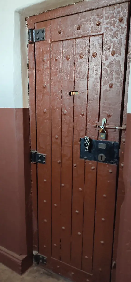 Heavy wooden jail door with iron locks and fittings